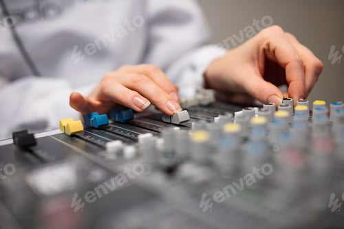 Preview: Midsection Of Radio Host's Hands Using Music Mixer In Studio