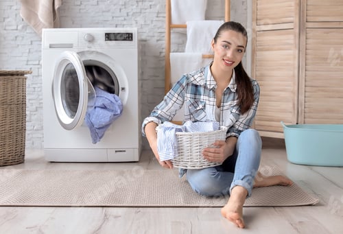 Preview: Young woman with laundry basket at home