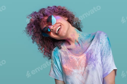Preview: Cheerful hipster woman in sunglasses dancing during Holi party