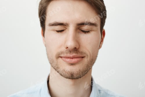 Preview: Close-up portrait of attractive young male model with bristle, standing with closed eyes and slight