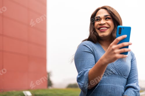 Preview: Close-up portrait of trans woman using cellphone and laughing