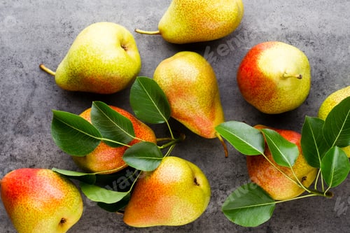 Preview: Fresh bio pear with leaves on the plate. Gray stone table.