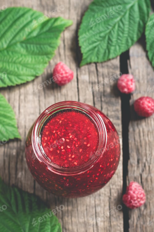 Preview: Jar with homemade raspberry jam. Ripe Berries and Leaves. Top view