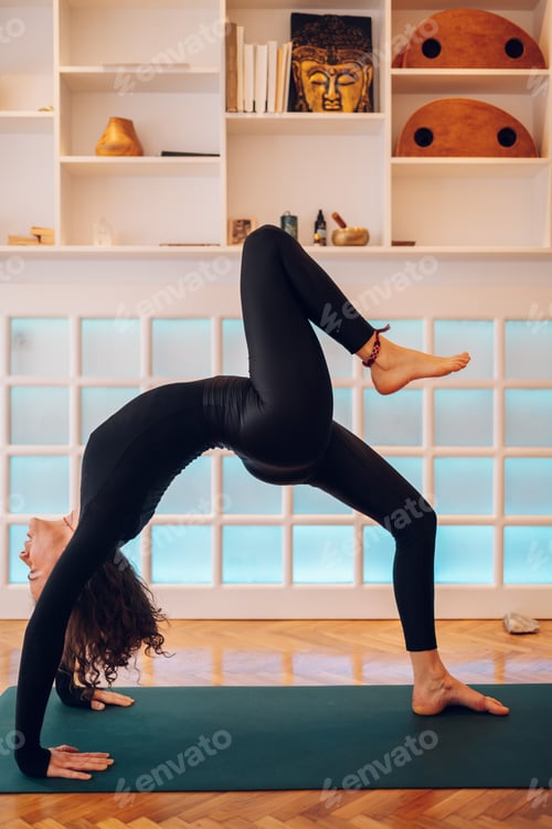 Preview: Girl practicing yoga while in a bridge pose with one leg lifted off the floor.