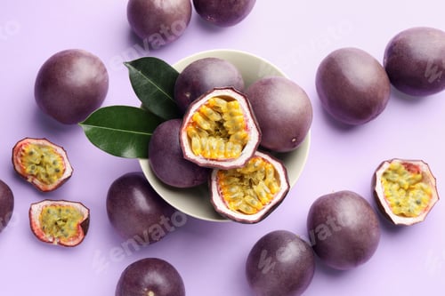 Preview: Fresh passion fruits with green leaves on violet background, flat lay