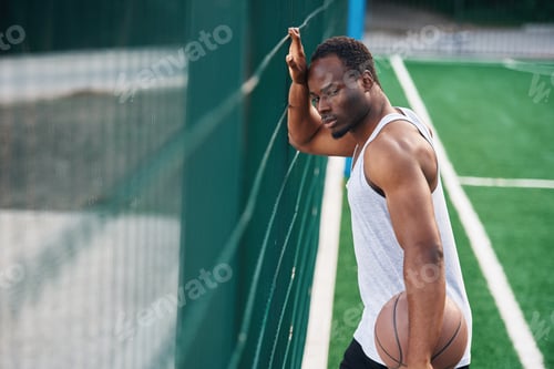 Preview: Young black man is with basketball ball outdoors