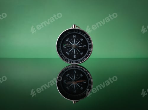 Preview: Closeup compass on green background with reflection