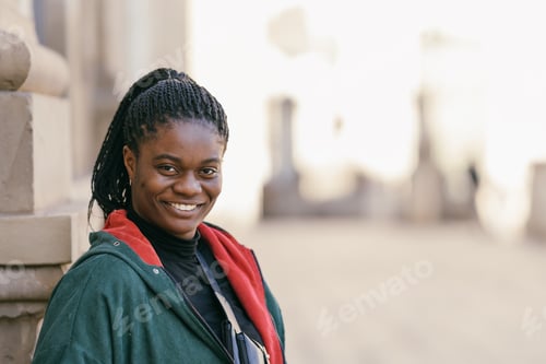 Preview: Portrait of a African woman smiling at the camera outdoors