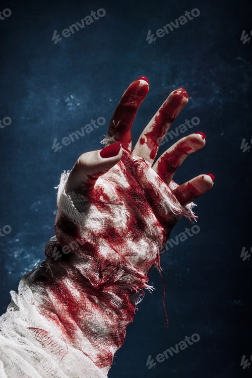 Preview: Scary bandaged bloody zombie hand on a dark background