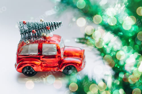 Preview: Red toy car with a Christmas tree in the palm. Festive New Year's gift. New Year post
