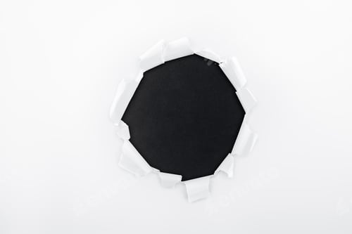 Preview: ragged hole in textured white paper on black background