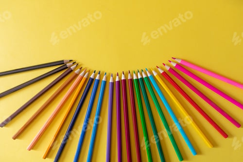 Preview: multicolored pencils on yellow background with copy space
