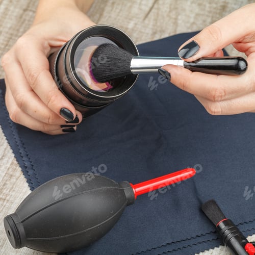 Preview: The photographer cleans the lens of the lens from dust.