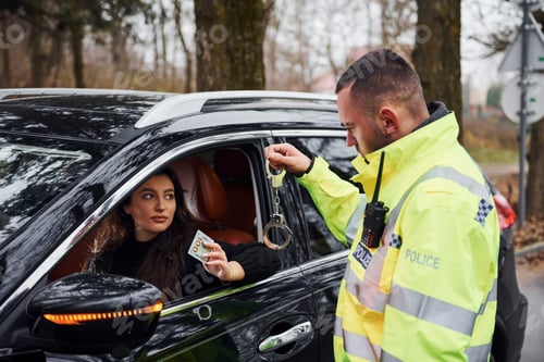 Preview: Male police officer in green uniform and with handcuffs refuse to take bribe from woman in vehicle