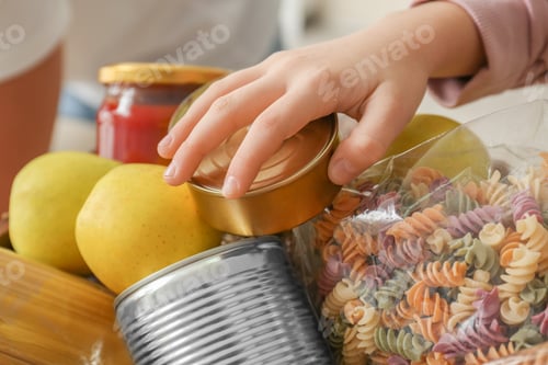 Preview: Girl taking food out of donation box, closeup