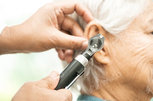 Preview: Audiologist or ENT doctor use otoscope checking ear of asian senior woman patient