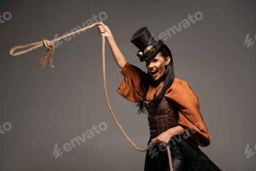 Preview: attractive steampunk girl in top hat holding lasso and screaming isolated on grey