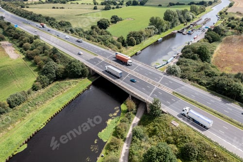 Preview: Aerial view directly above a busy UK motorway bridge over a river