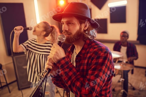 Preview: Bearded Young Man Singing with Band