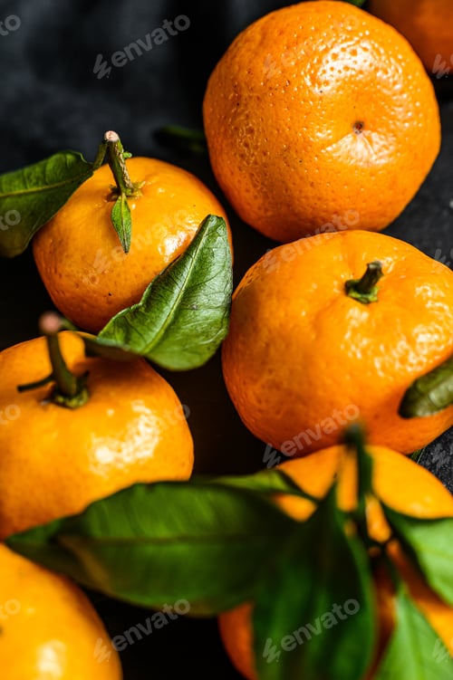 Preview: Tangerines, mandarines with leaves. Black background. Top view
