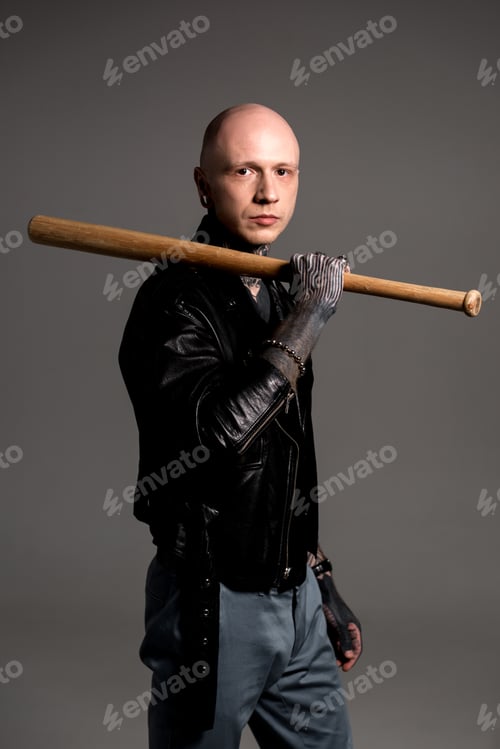 Preview: stylish bald man with tattoos holding baseball bat and looking at camera isolated on grey