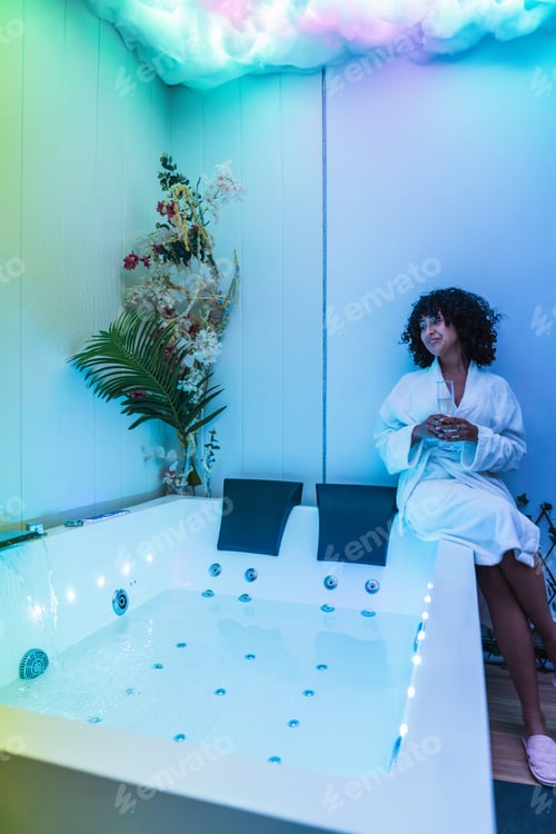 Preview: Woman relaxing in modern spa with hydromassage tub