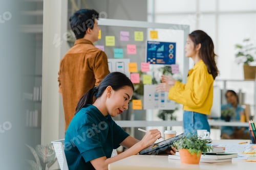 Preview: Asia young businesswoman using pen with digital tablet computer in modern office.