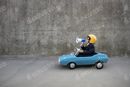 Preview: Funny businessman driving retro pedal car outdoor