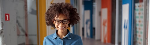 Preview: Smiling pretty lady posing while carrying a box of documents in the office