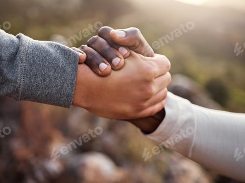 Preview: Cropped shot of an unrecognizable man helping his friend along a mountain during their hike