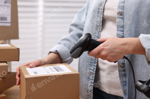 Preview: Parcel packing. Post office worker with scanner reading barcode indoors, closeup