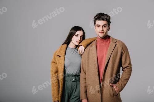 Preview: beautiful stylish couple posing in beige coats, isolated on grey