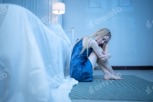 Preview: A young woman in blue pajamas feels sad after receiving information from her phone