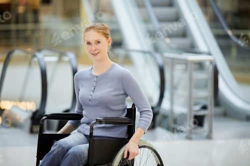 Preview: Young woman in wheelchair in shopping mall