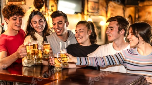 Preview: Happy young friends group toasting and drinking beer at counter at brewery bar restaurant
