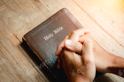 Visualização: Hands of prayer on a Holy Bible on wood table with window light.christian backgound