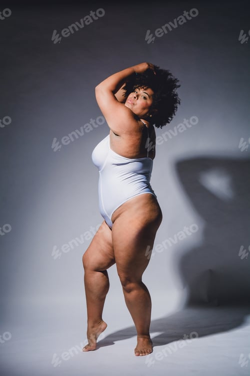 Preview: young woman posing in white lingerie confident and empowered, studio shot.