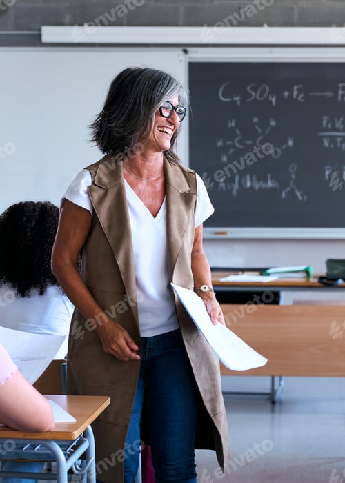Preview: Smiling teacher giving lecture to diverse high school students in classroom