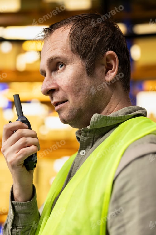Preview: Professional warehouse employee using wireless radio transmitter