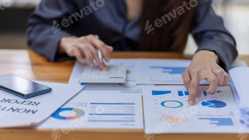 Preview: Asian Businesswoman Using laptop computer and working at office with calculator document on desk,