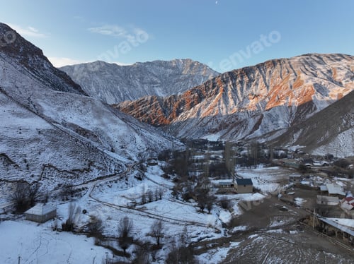 Preview: Snowy mountain valley with a village and contrasting light