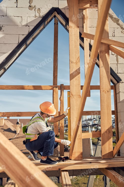 Preview: Concentrated young builder looking at the beam