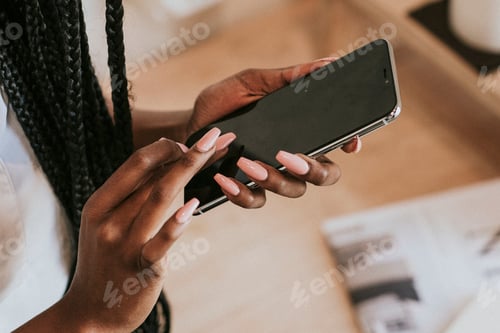 Preview: Black woman texting on her mobile phone
