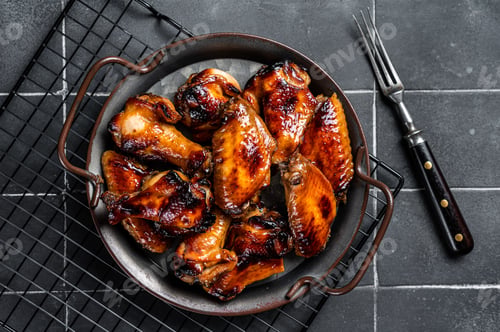 Preview: BBQ chicken wings in dip Barbecue sauce. Black background. Top view