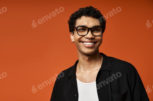 Preview: Smiling Man in Stylish Glasses on Bright Orange Background
