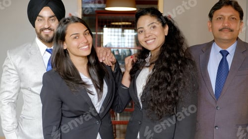 Preview: Group of Indian co-workers wearing suits in office