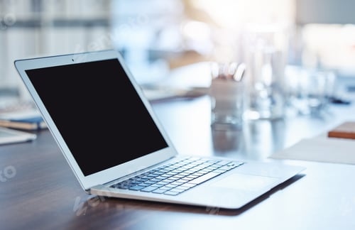 Preview: Closeup of a laptop with a blank black screen on a wooden desk in an empty office. Macro view of te