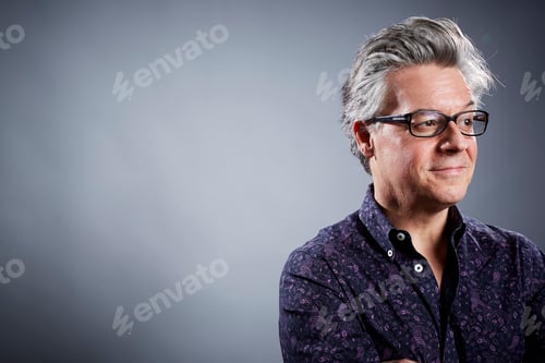Preview: Studio portrait of mature businessman looking away