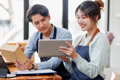 Preview: Startup small business SME. Two Young Asian business entrepreneurs using laptop computer check onlin