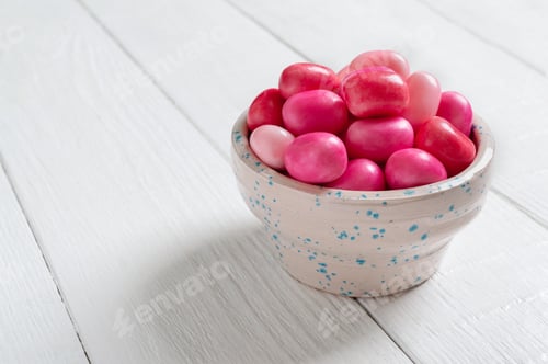 Preview: Colorful gum in a bowl on a white wooden background. Holiday concept, baby treats.